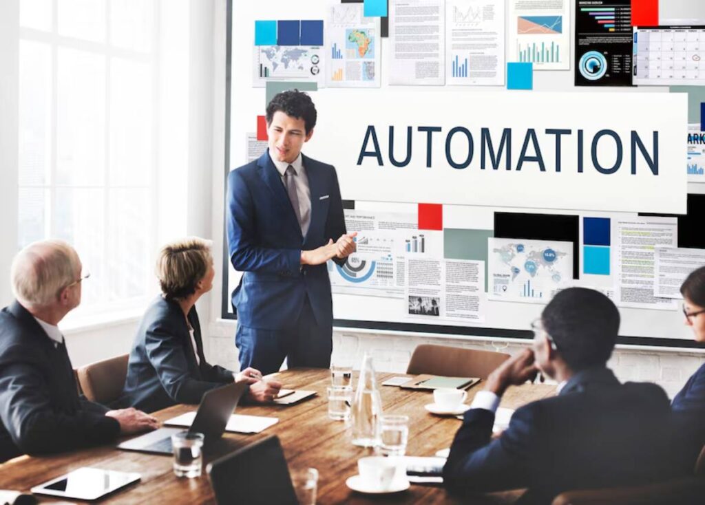 A man presents on automation to a group of professionals in a modern office setting.